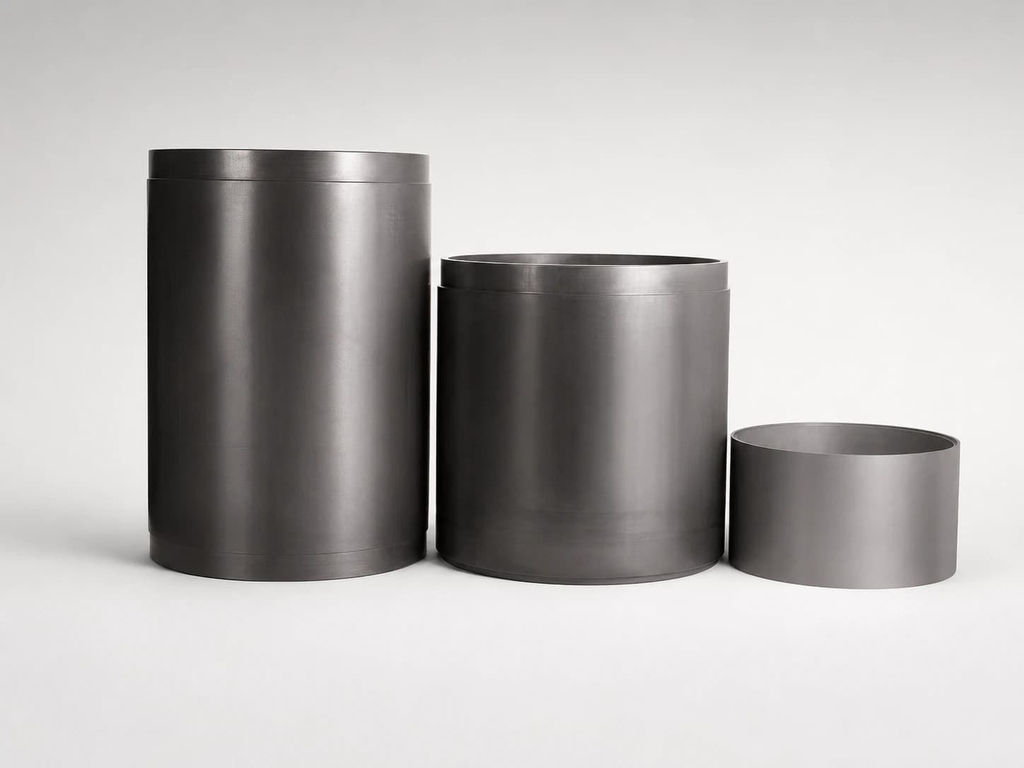 Three cylindrical silicon carbide wear liners in different industrial sizes