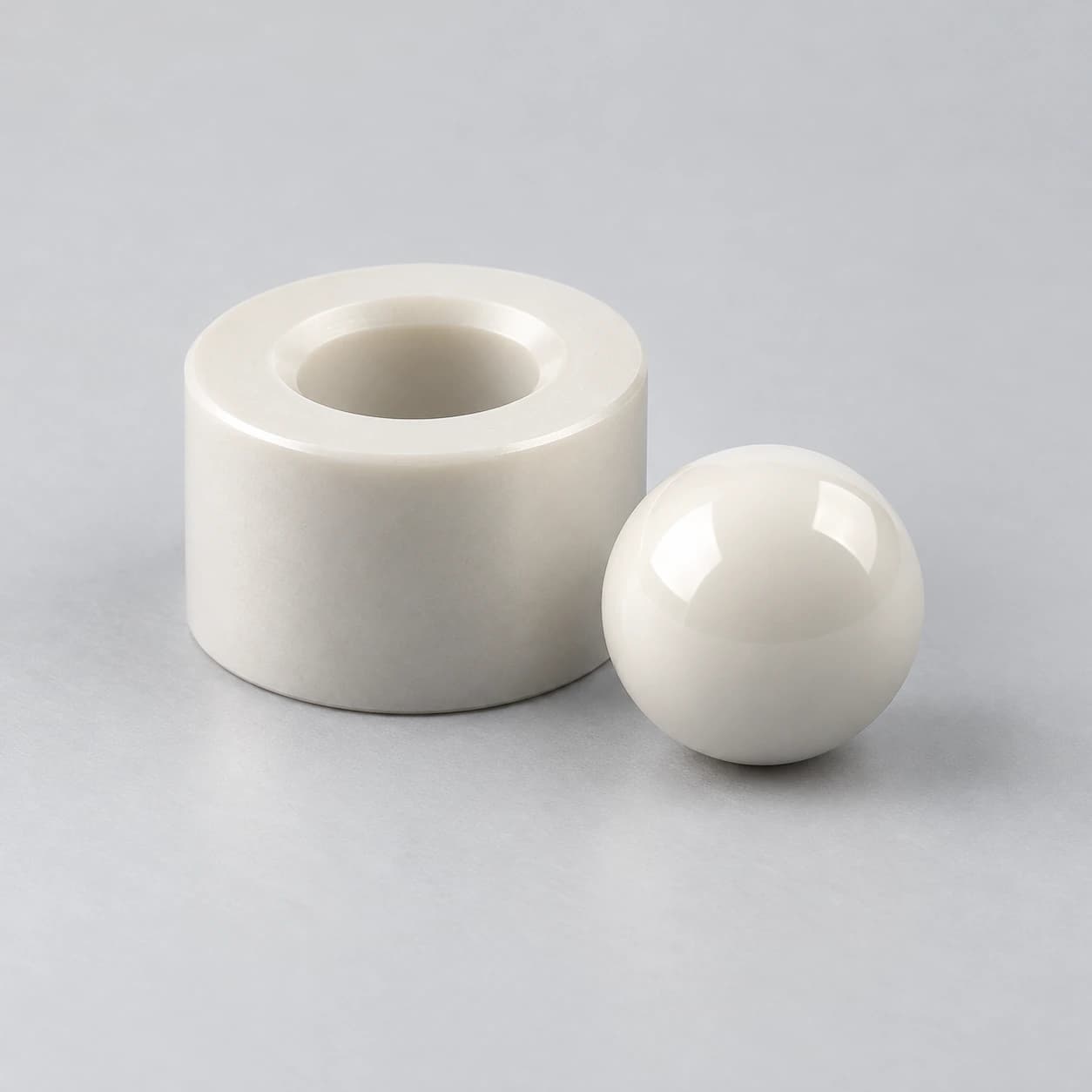 Illustrative ceramic valve ball beside a separate seat