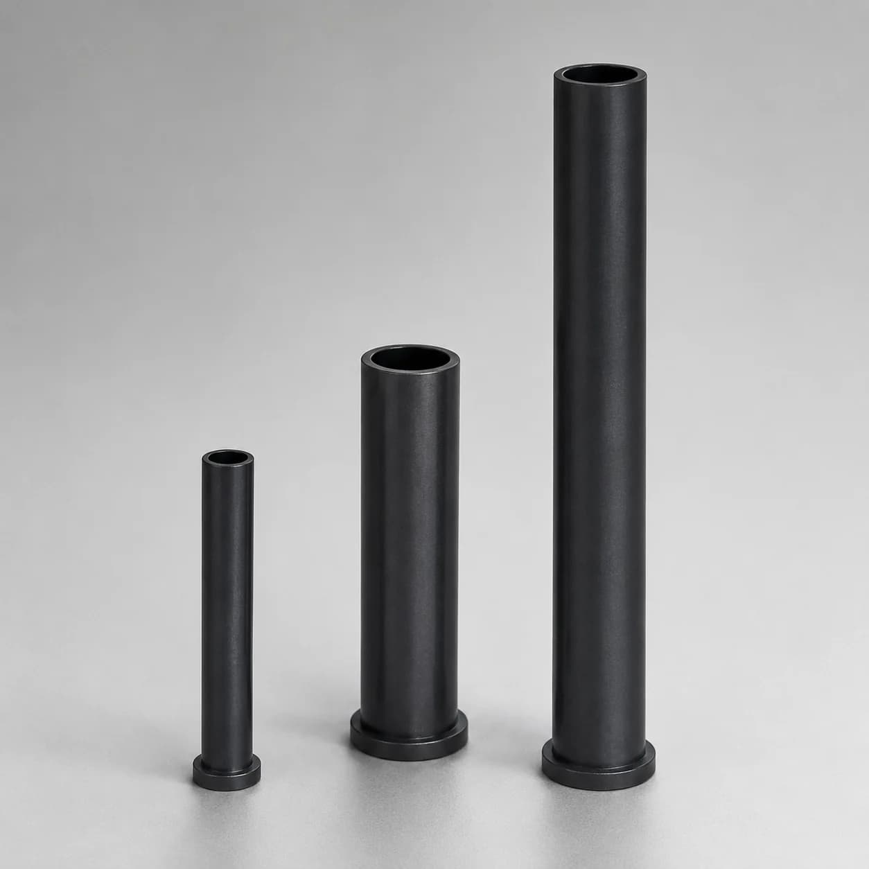 Three silicon nitride riser tubes with flanged bases in different sizes