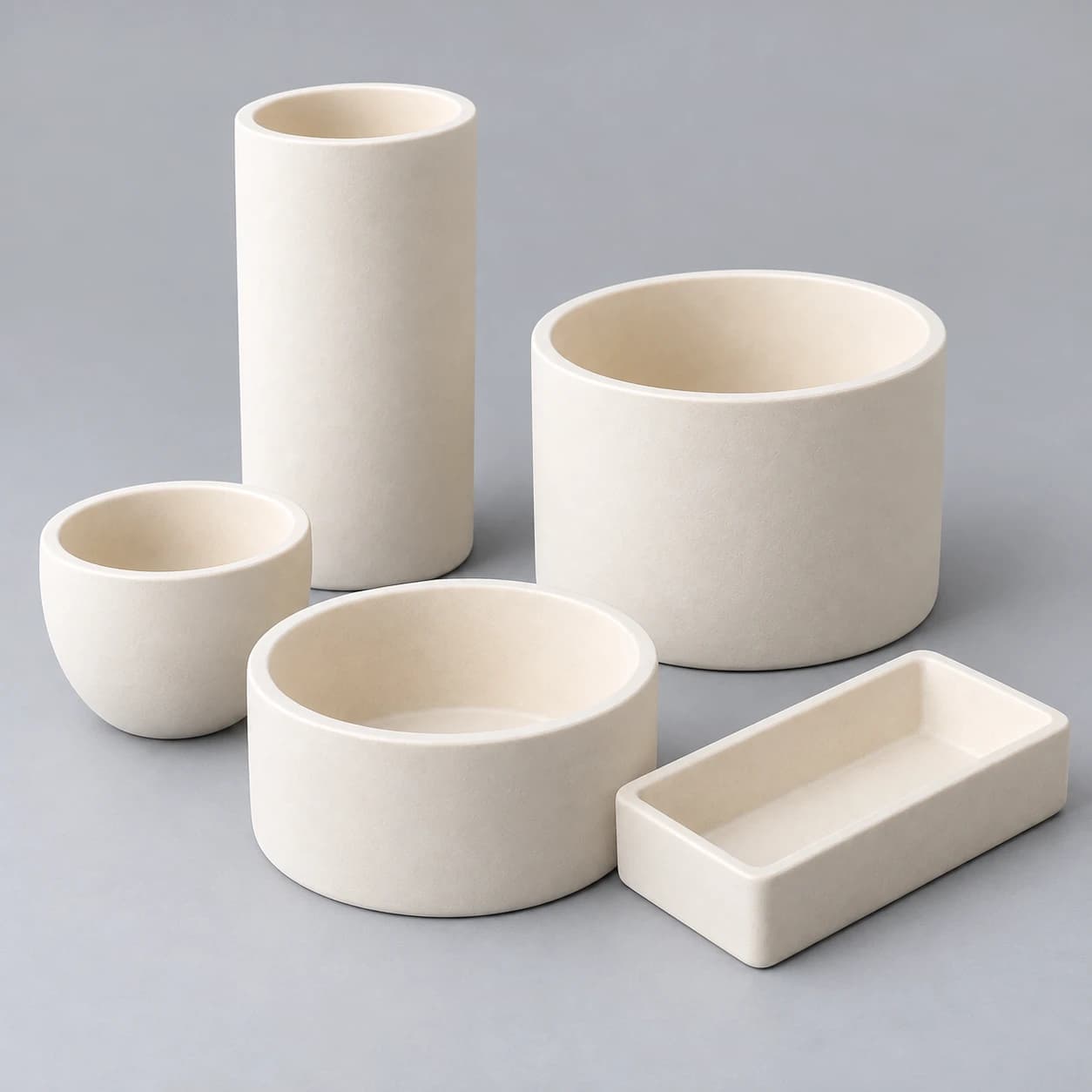 Conceptual alumina vessel family: tall and wide cylindrical crucibles, rounded cup and shallow rectangular tray