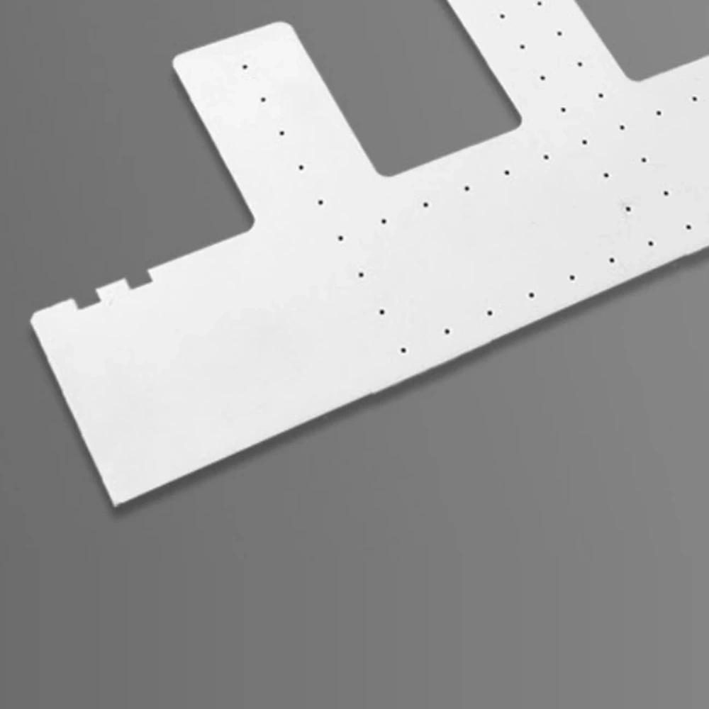 Detail view of machined alumina ceramic carrier with holes and cut-outs