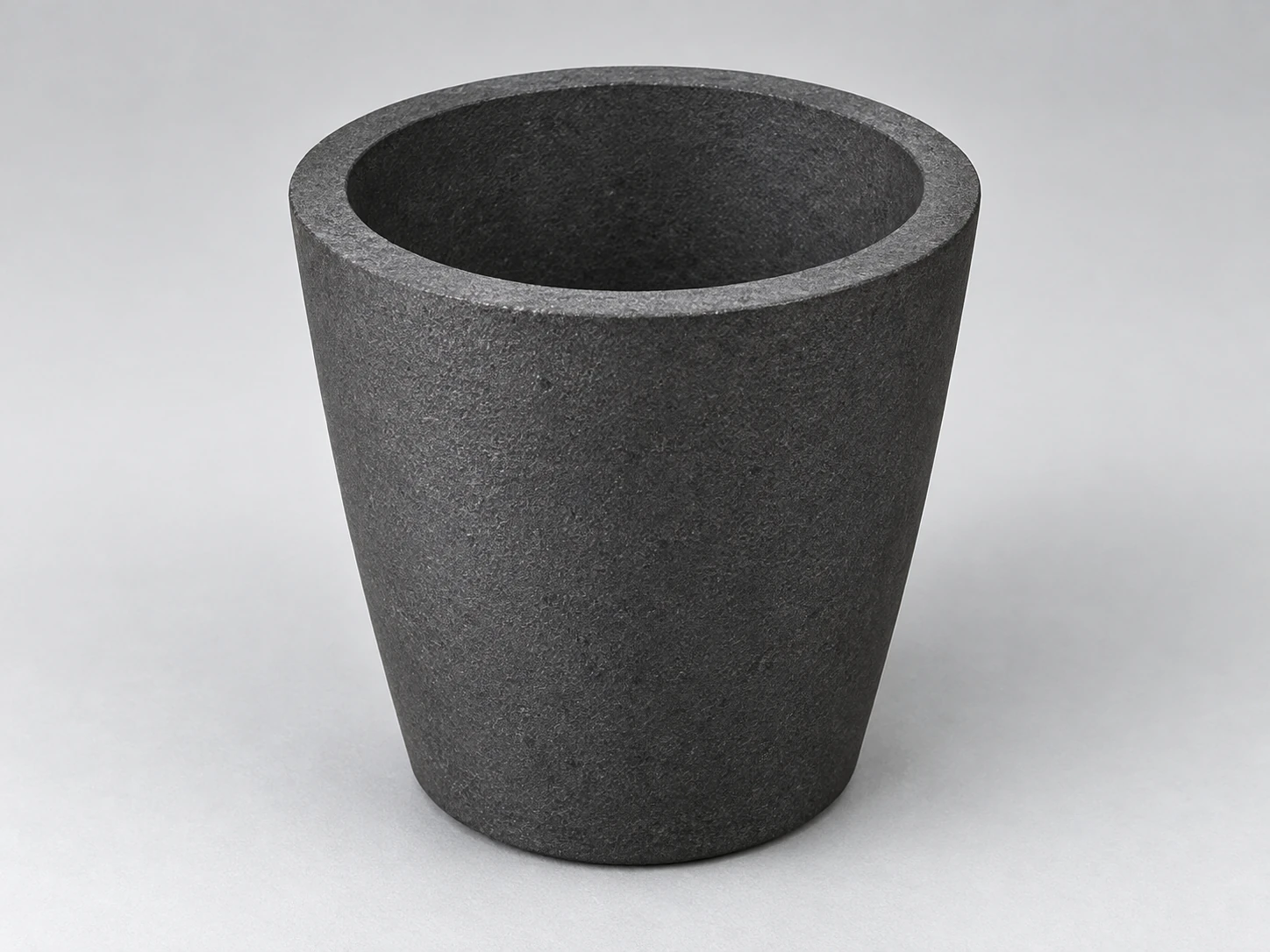 Independent conceptual view of a silicon-carbide-containing foundry crucible with tapered body and open rim