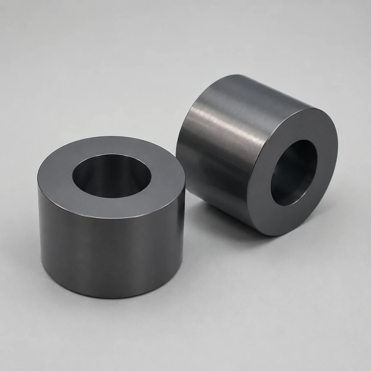 Two silicon nitride sleeves showing representative bore and outside diameter geometry